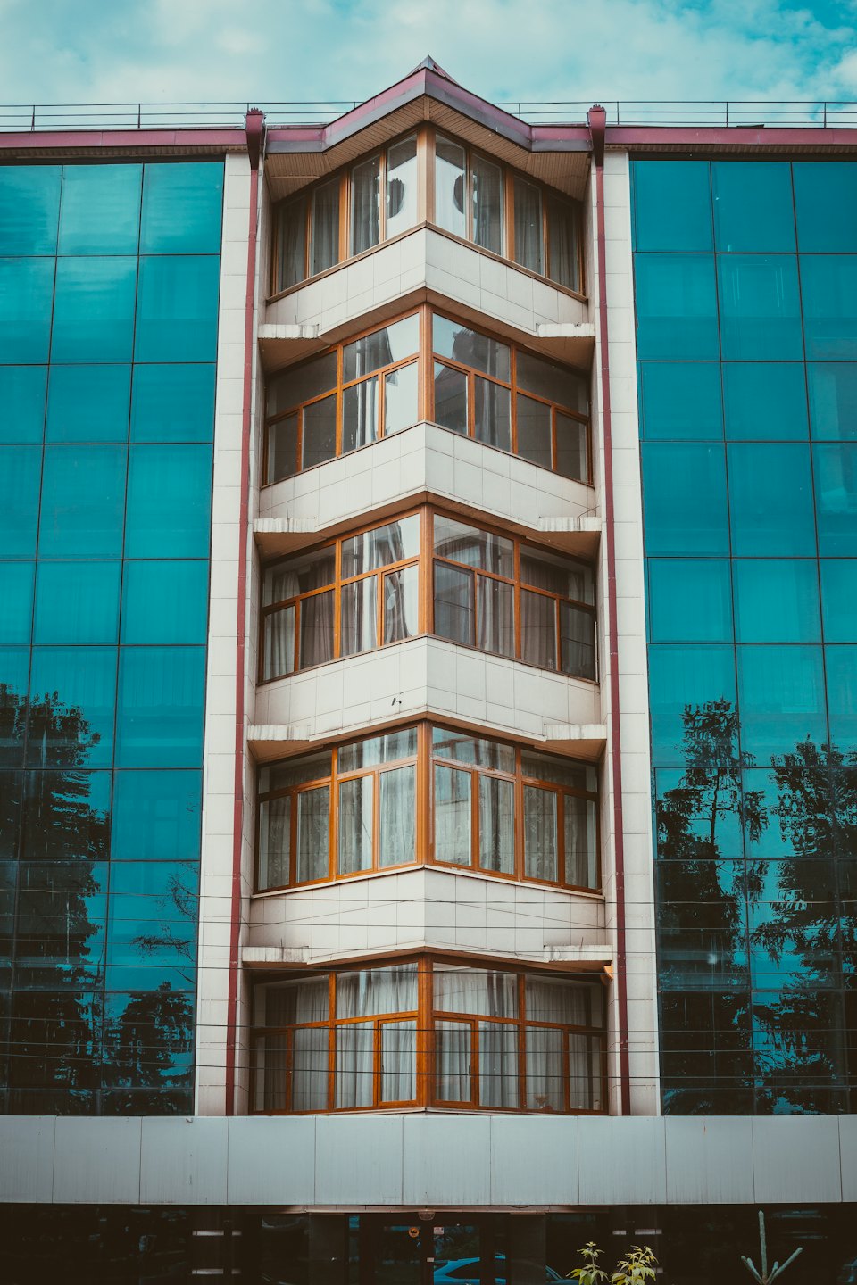 Edificio moderno con finestre a telaio in legno e pannelli in vetro blu.
