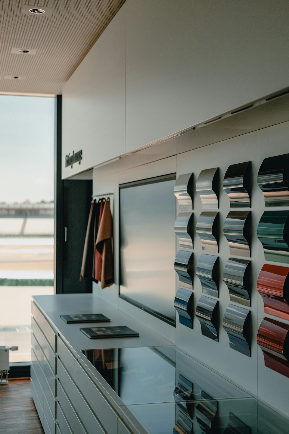 Showroom moderno con campioni di materiali automobilistici e un'ampia finestra.